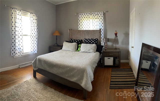 bedroom featuring wood finished floors and baseboards