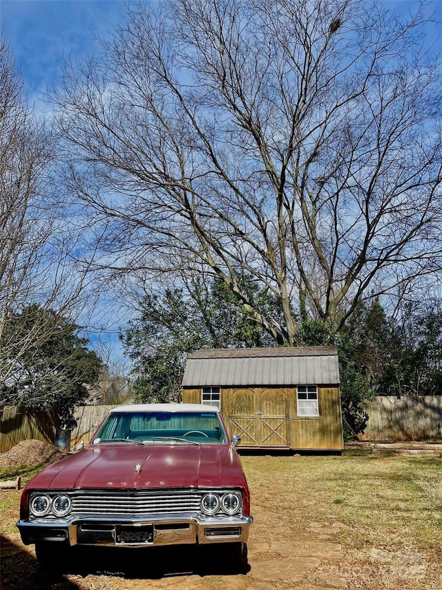 view of yard with an outdoor structure, a storage shed, and fence