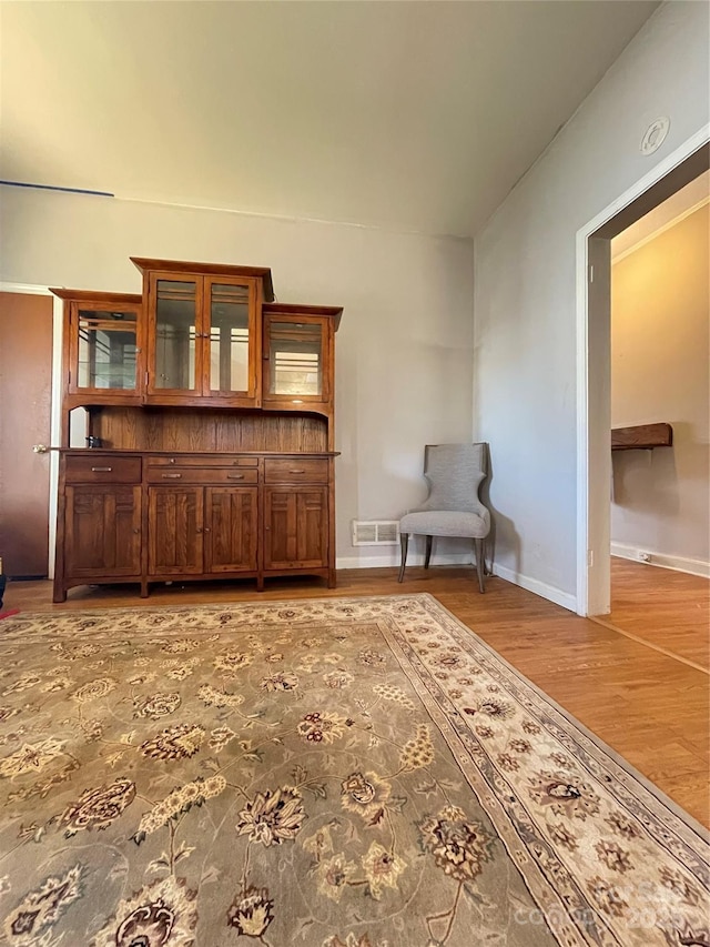 living area with visible vents, light wood-style flooring, and baseboards