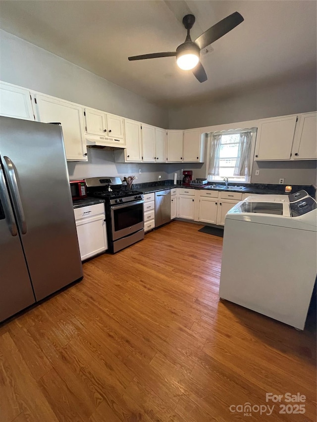 kitchen with appliances with stainless steel finishes, white cabinets, and under cabinet range hood