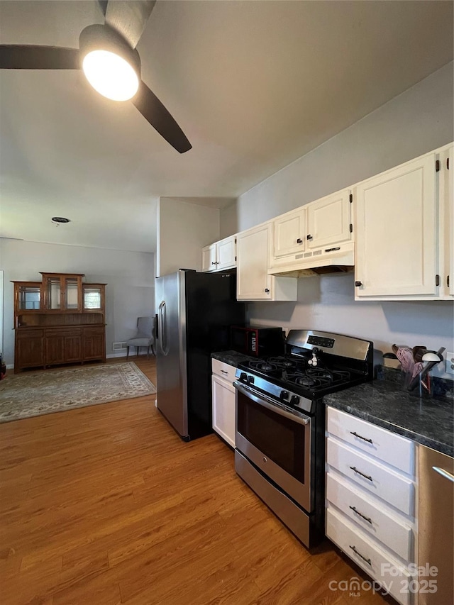 kitchen with white cabinets, a ceiling fan, appliances with stainless steel finishes, light wood-type flooring, and under cabinet range hood