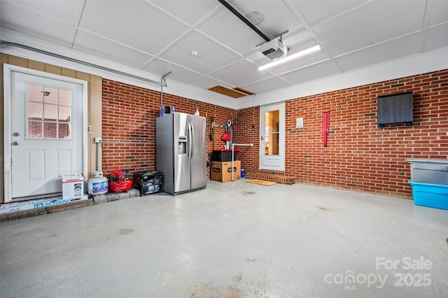 garage featuring a garage door opener and stainless steel fridge with ice dispenser