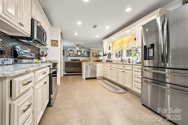 kitchen featuring light stone counters, light tile patterned floors, ceiling fan, stainless steel appliances, and decorative backsplash