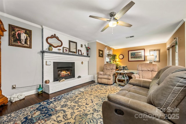 living room with ornamental molding, a brick fireplace, and dark hardwood / wood-style floors