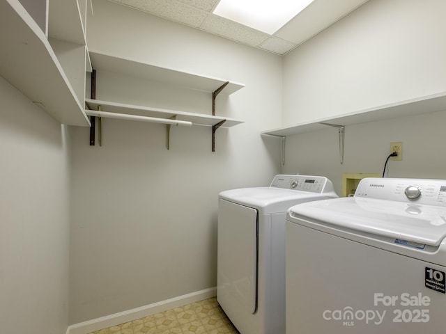 washroom featuring laundry area, baseboards, separate washer and dryer, and light floors