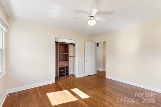 unfurnished bedroom featuring hardwood / wood-style flooring, ceiling fan, and a closet