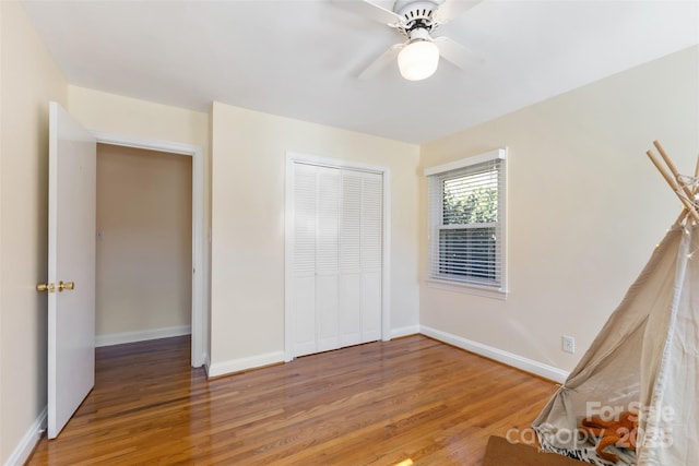 unfurnished bedroom featuring hardwood / wood-style flooring, ceiling fan, and a closet