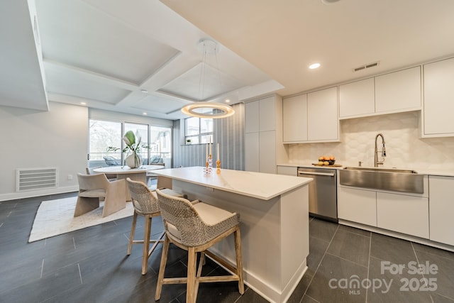 kitchen with dishwasher, decorative backsplash, a center island, sink, and white cabinetry