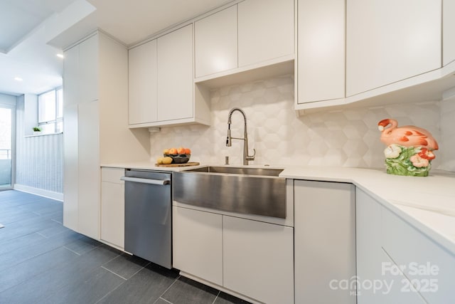 kitchen with white cabinetry, backsplash, stainless steel dishwasher, and sink