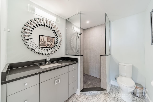 bathroom featuring vanity, tiled shower, and toilet