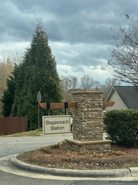 community / neighborhood sign featuring fence