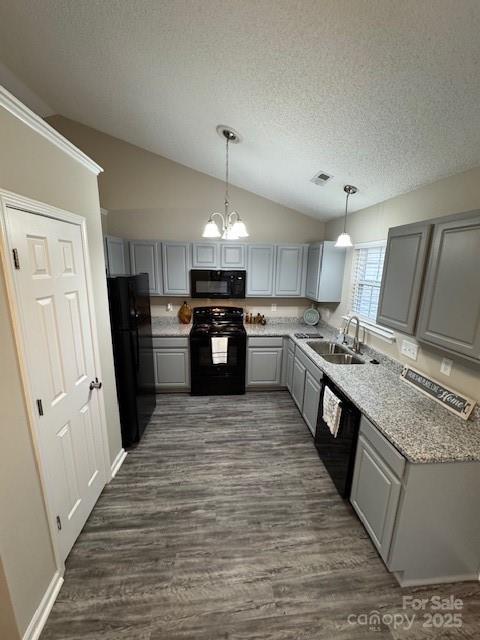 kitchen with dark wood finished floors, visible vents, gray cabinetry, a sink, and black appliances