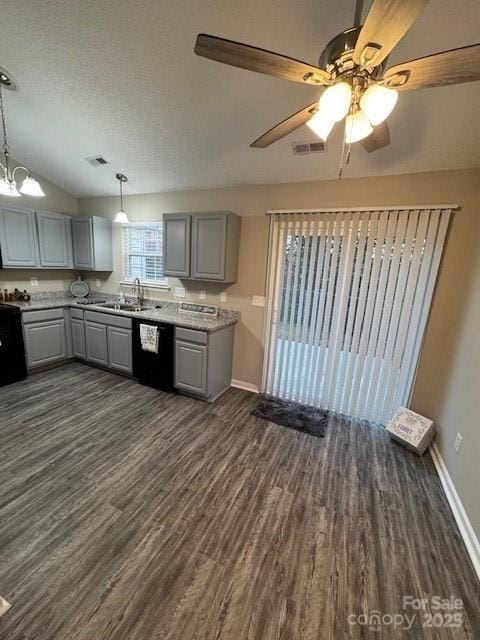 kitchen with black dishwasher, visible vents, dark wood finished floors, gray cabinetry, and a sink