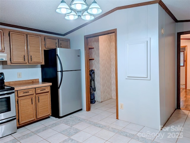 kitchen featuring hanging light fixtures, stainless steel appliances, lofted ceiling, light tile patterned flooring, and ornamental molding