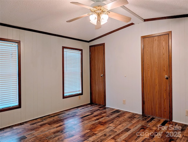 spare room with dark wood-type flooring, crown molding, and a textured ceiling