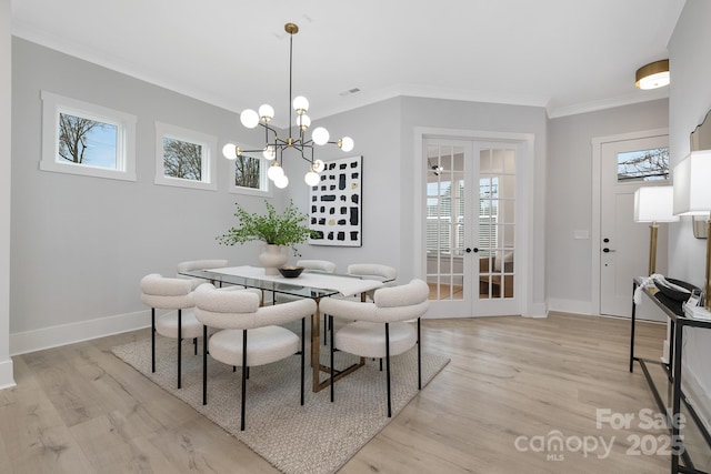 dining space with french doors, crown molding, and light hardwood / wood-style flooring