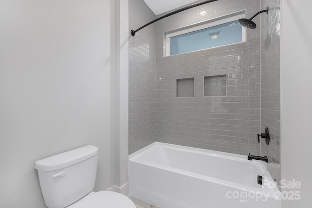 bathroom featuring toilet and tiled shower / bath combo