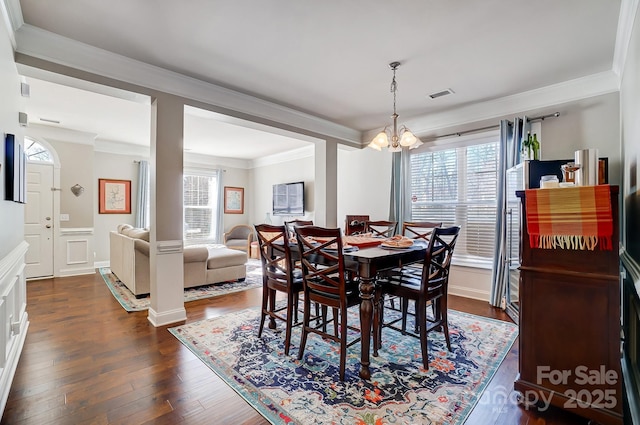 dining room featuring a chandelier, dark wood-type flooring, visible vents, and crown molding