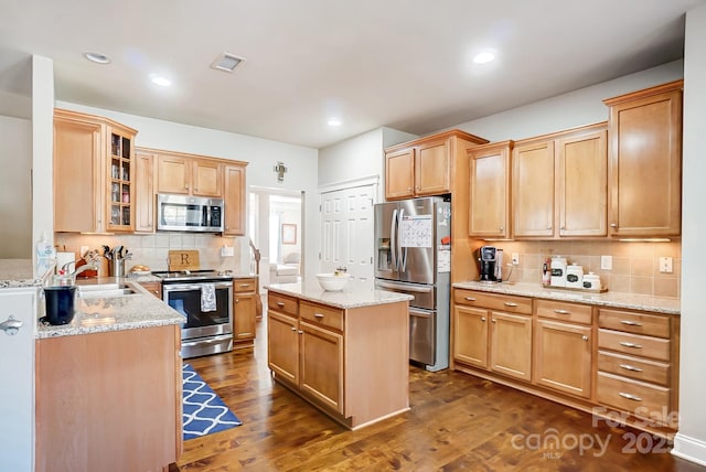 kitchen featuring dark wood-style floors, appliances with stainless steel finishes, a sink, and glass insert cabinets