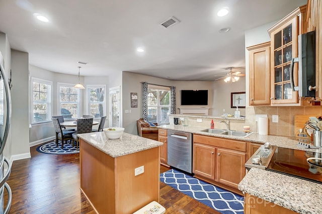 kitchen with dark wood-style flooring, stainless steel appliances, backsplash, a sink, and light stone countertops