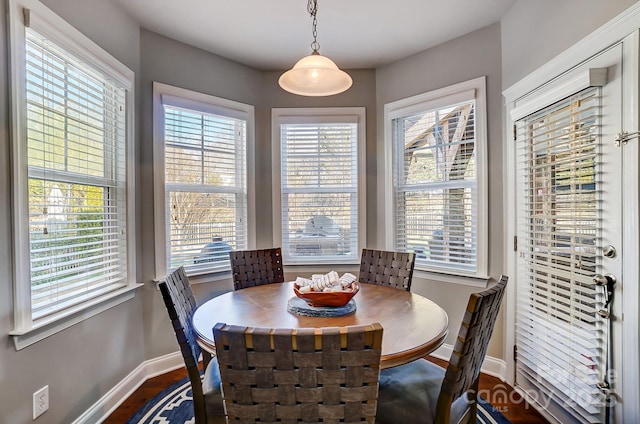 dining space featuring dark wood-style floors and baseboards