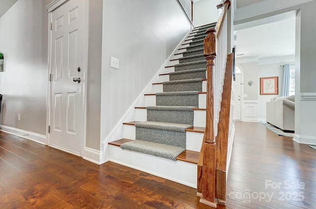 staircase with wood-type flooring and baseboards