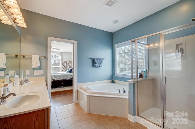 ensuite bathroom with plenty of natural light, visible vents, tile patterned floors, a garden tub, and a sink