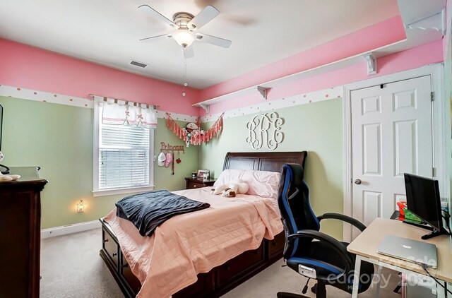 carpeted bedroom featuring baseboards, visible vents, and a ceiling fan