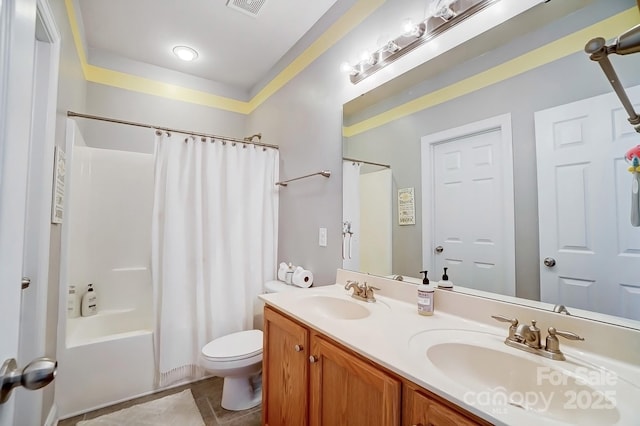 bathroom with double vanity, a sink, toilet, and shower / bath combo with shower curtain