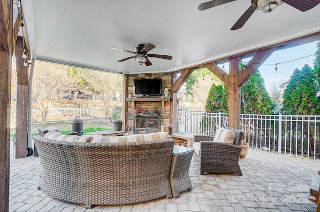 view of patio featuring fence and an outdoor living space with a fireplace