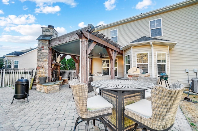 view of patio with fence, a ceiling fan, and outdoor dining space