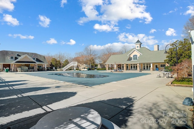 pool with a water slide and a patio area