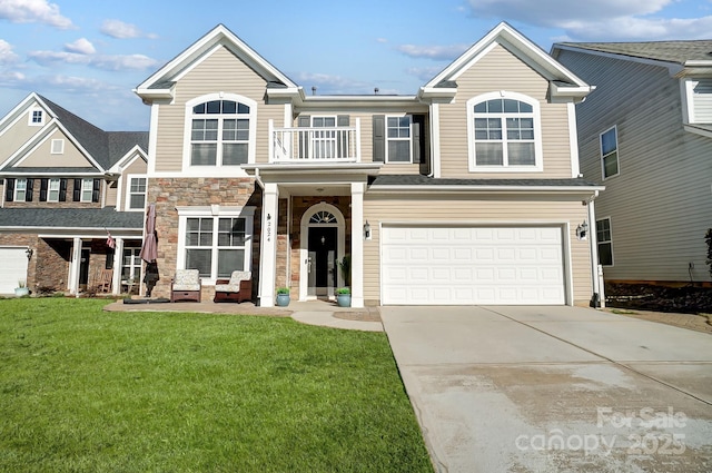 view of front of home featuring an attached garage, a front yard, a balcony, stone siding, and driveway