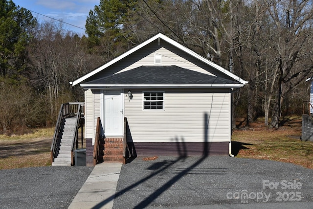 view of front of house featuring entry steps and roof with shingles