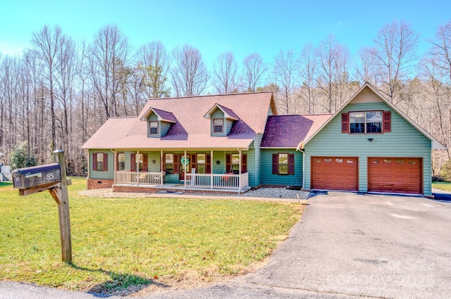 view of front of house with a porch, a garage, and a front lawn