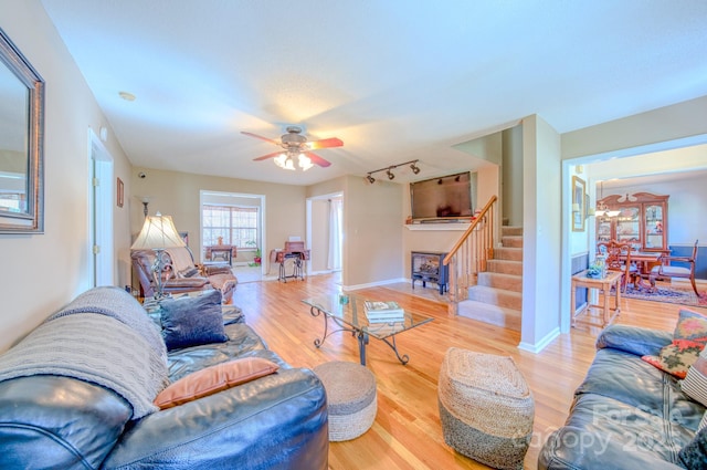 living room featuring ceiling fan, track lighting, and wood-type flooring