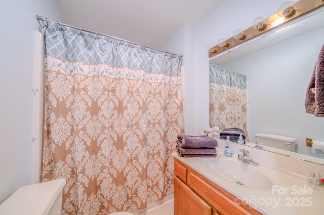 bathroom featuring vanity, a textured ceiling, and toilet