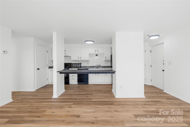 kitchen with white cabinetry, sink, and light hardwood / wood-style floors