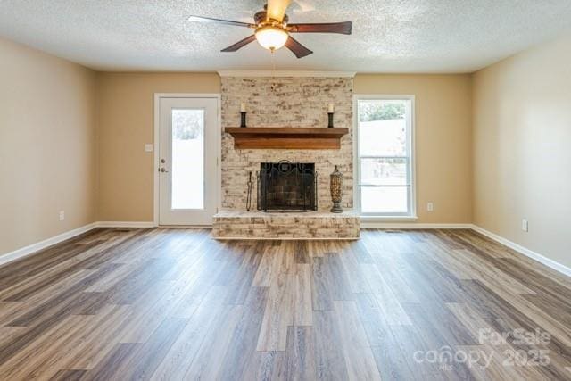 6108 Gold Creek Estate Dr, Hickory, NC 28601 - unfurnished living room featuring a textured ceiling, wood finished floors, a ceiling fan, and a fireplace