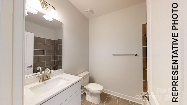 bathroom with vanity, toilet, baseboards, and visible vents