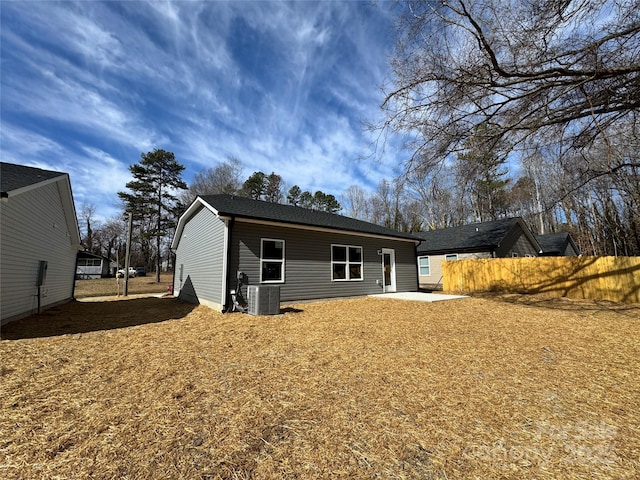 rear view of house featuring a patio area, central AC unit, and fence