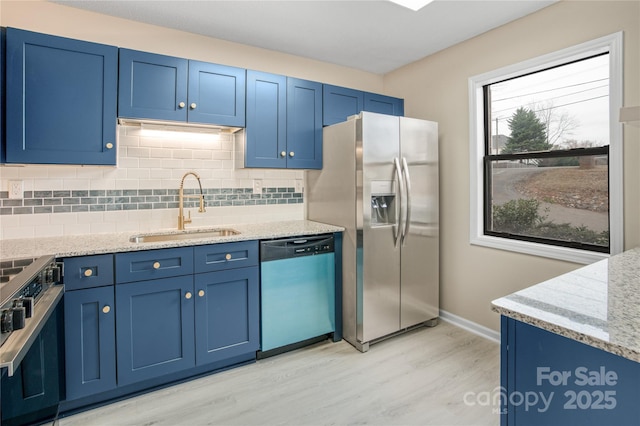 kitchen with tasteful backsplash, stainless steel appliances, blue cabinets, and sink