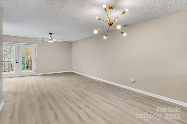 unfurnished room with french doors, ceiling fan with notable chandelier, a textured ceiling, and light wood-type flooring