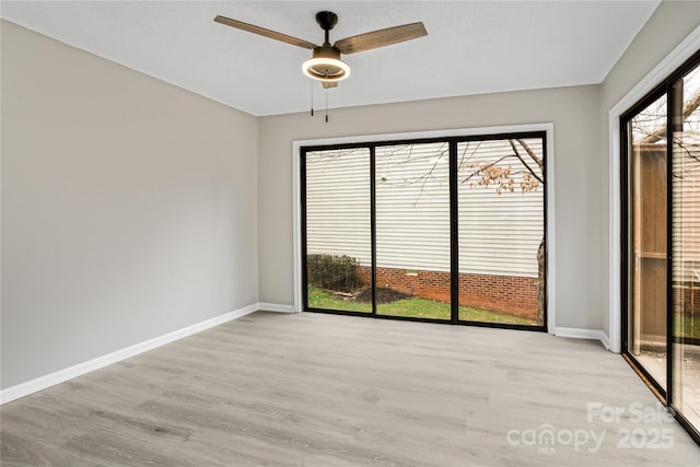 empty room featuring ceiling fan and light hardwood / wood-style floors