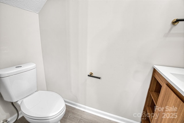 bathroom featuring vanity, hardwood / wood-style floors, and toilet