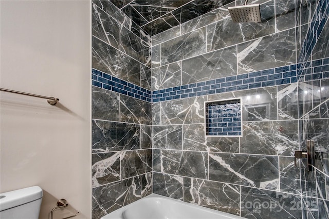 bathroom with toilet and tiled shower / bath combo