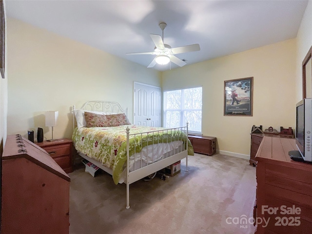 carpeted bedroom with ceiling fan and a closet