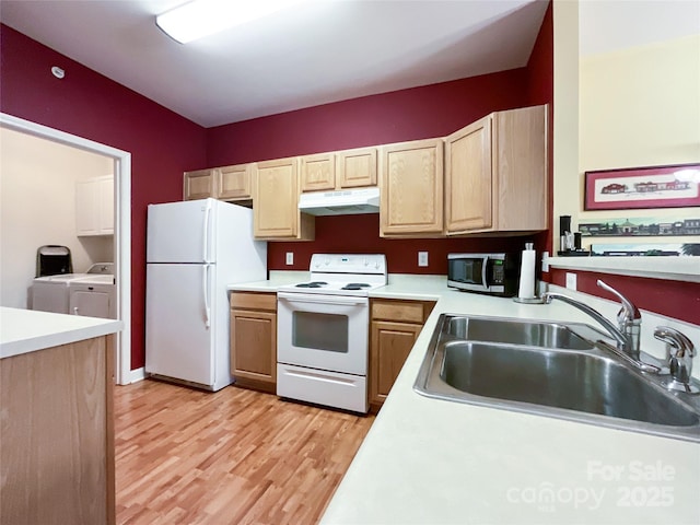 kitchen featuring sink, white appliances, separate washer and dryer, light wood-type flooring, and light brown cabinets