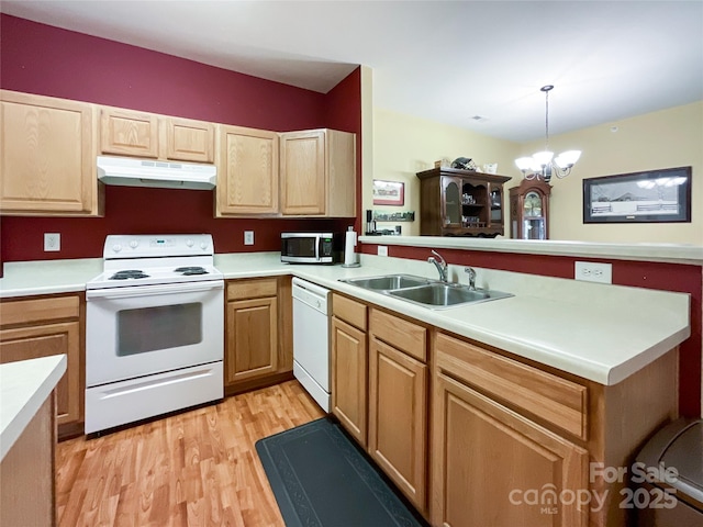 kitchen with pendant lighting, sink, white appliances, light hardwood / wood-style floors, and a chandelier