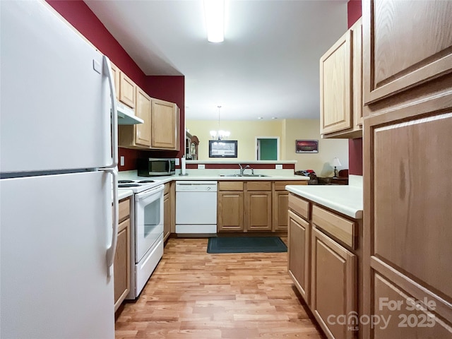 kitchen featuring decorative light fixtures, sink, white appliances, kitchen peninsula, and light wood-type flooring